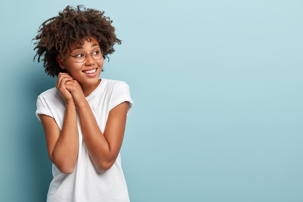 Junge Frau mit Afro-Haarschnitt, die weißes T-Shirt trägt