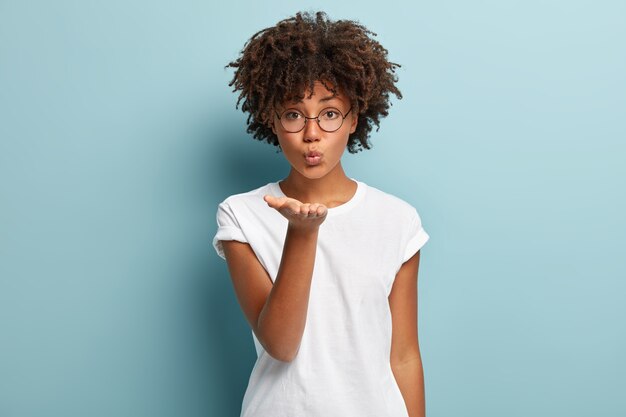 Junge Frau mit Afro-Haarschnitt, die weißes T-Shirt trägt