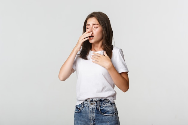 Junge Frau mit Allergie Niesen. Mädchen, das krank fühlt, laufende Nase zu haben.