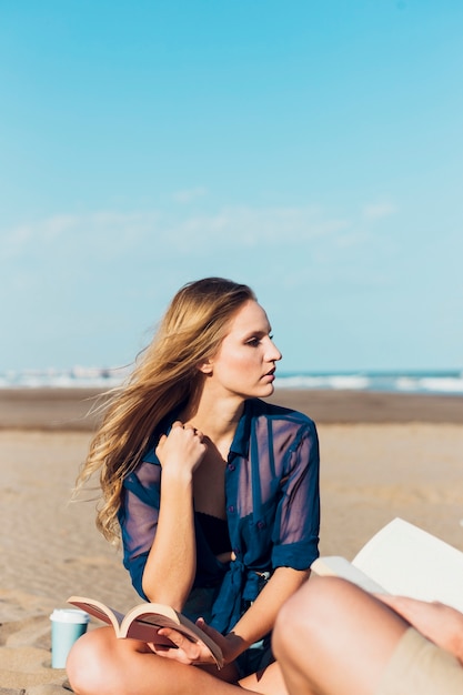 Junge Frau mit Buch auf Strand