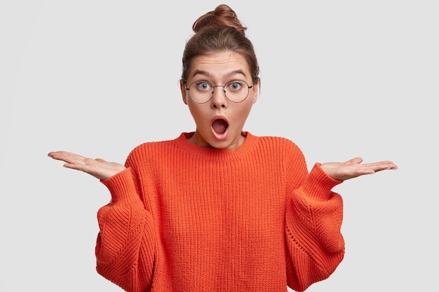 Junge Frau mit den Haaren in einem Brötchen, das einen roten Pullover trägt