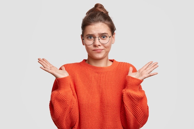 Junge Frau mit den Haaren in einem Brötchen, das einen roten Pullover trägt