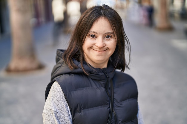 Junge Frau mit Down-Syndrom lächelt selbstbewusst auf der Straße