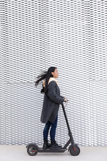 Junge Frau mit Elektroroller