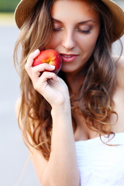 Junge Frau mit frischem Pfirsich in ihrer Hand