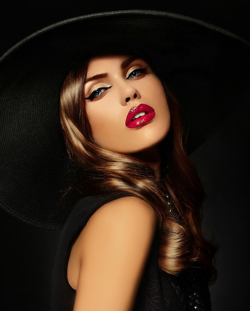 Junge Frau mit hellem Make-up und schwarzem Hut