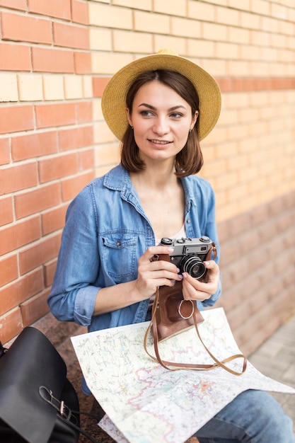 Kostenloses Foto junge frau mit hut, die kamera hält