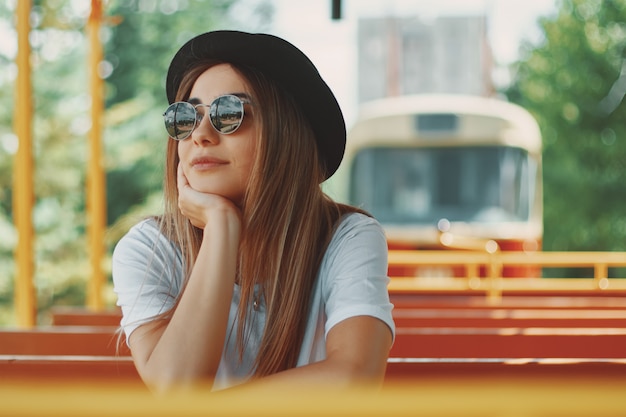 Junge Frau mit Hut und Sonnenbrille auf einer Stadtrundfahrt