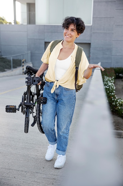 Kostenloses Foto junge frau mit ihrem faltrad