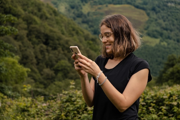 Junge Frau mit ihrem Handy in der Natur