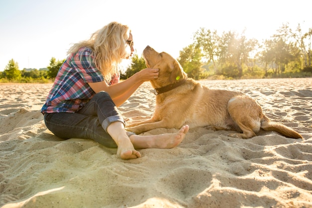 Kostenloses Foto junge frau mit ihrem hund am strand