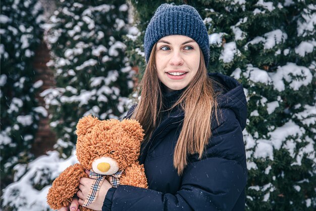 Junge Frau mit ihrem Lieblings-Teddybär im Arm im Winter