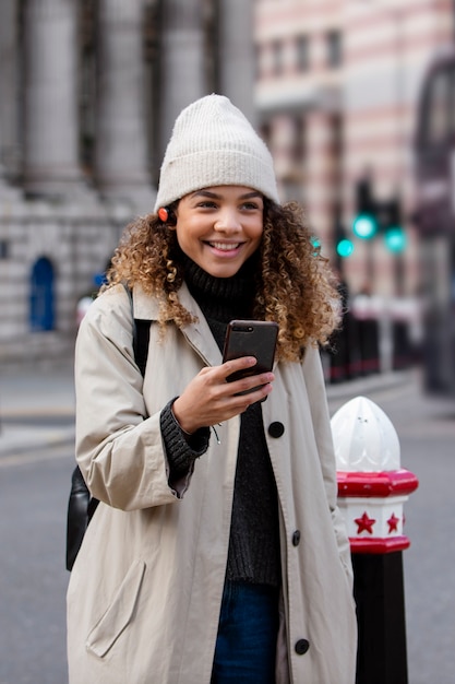 Junge Frau mit ihrem Smartphone in der Stadt