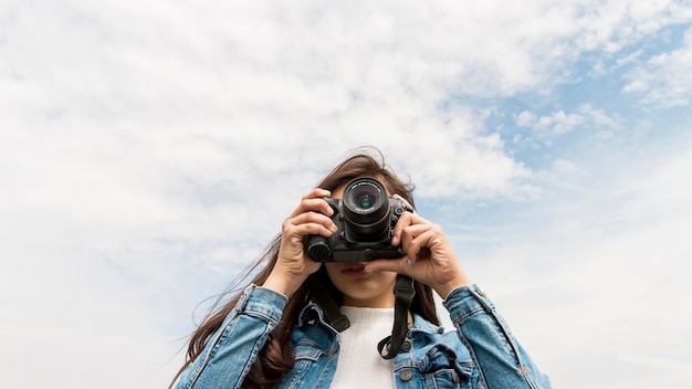 Junge Frau mit Kamera, die Fotos macht