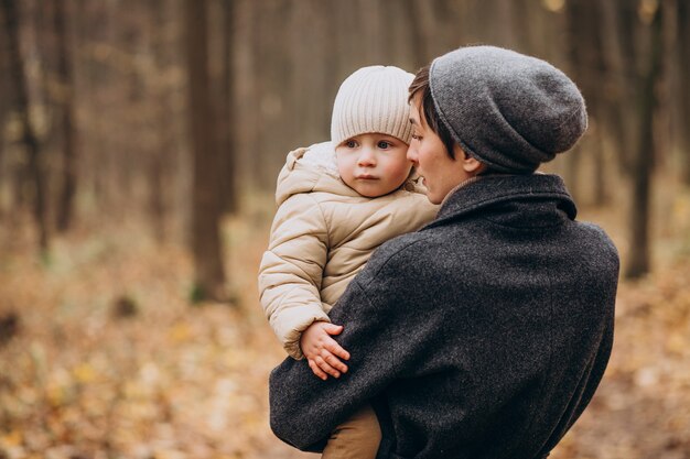 Junge Frau mit Kindern, die im Herbstpark gehen