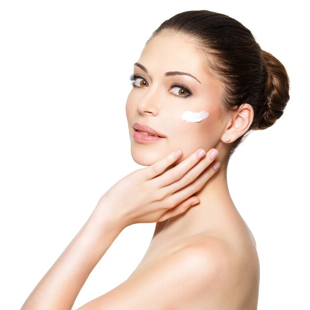 Junge Frau mit kosmetischer Creme auf einem sauberen frischen Gesicht. Hautpflegekonzept