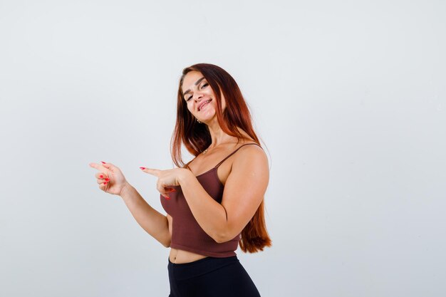 Junge Frau mit langen Haaren in einem braunen bauchfreien Top