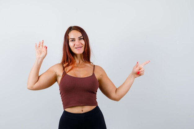 Junge Frau mit langen Haaren in einem braunen bauchfreien Top