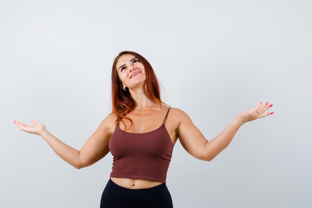 Junge Frau mit langen Haaren in einem braunen bauchfreien Top