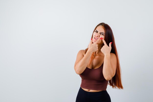 Junge Frau mit langen Haaren in einem braunen bauchfreien Top