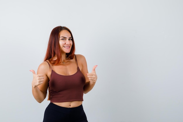 Junge Frau mit langen Haaren in einem braunen bauchfreien Top