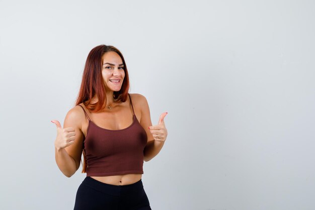 Junge Frau mit langen Haaren in einem braunen bauchfreien Top