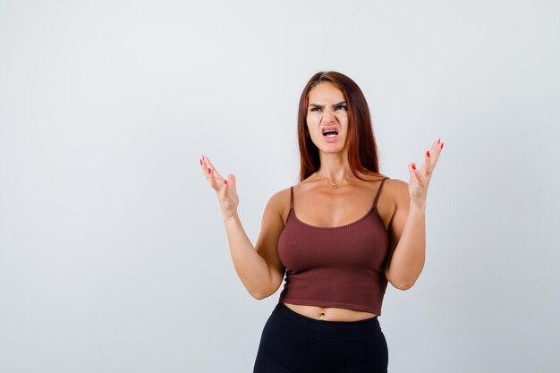 Junge Frau mit langen Haaren in einem braunen bauchfreien Top