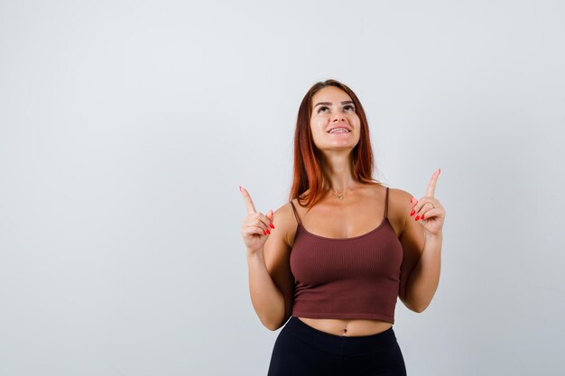 Junge Frau mit langen Haaren in einem braunen bauchfreien Top