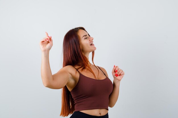 Junge Frau mit langen Haaren in einem braunen bauchfreien Top