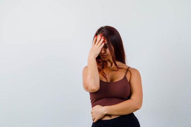 Junge Frau mit langen Haaren in einem braunen bauchfreien Top