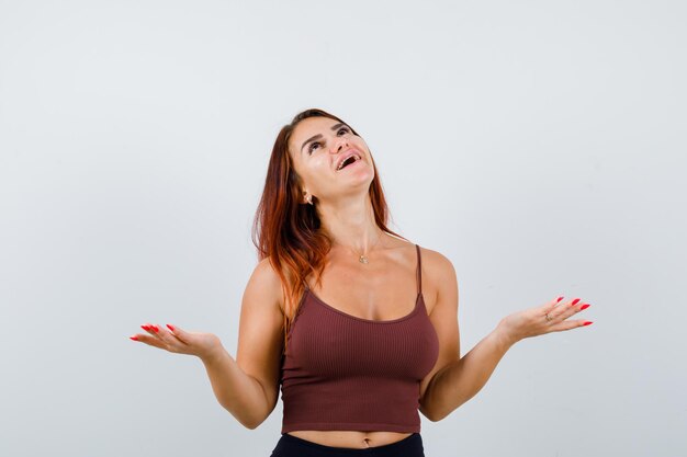 Junge Frau mit langen Haaren in einem braunen bauchfreien Top