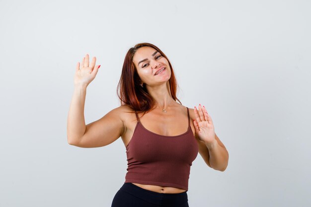 Junge Frau mit langen Haaren in einem braunen bauchfreien Top