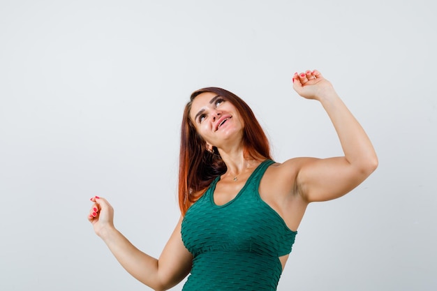 Junge Frau mit langen Haaren in einem grünen Bodycon