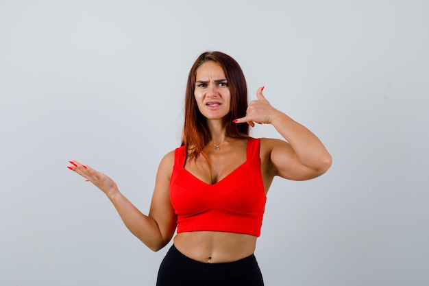 Junge Frau mit langen Haaren in einem orangefarbenen Trägershirt