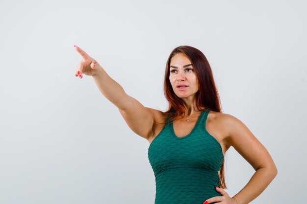 Junge Frau mit langen Haaren trägt einen grünen Bodycon