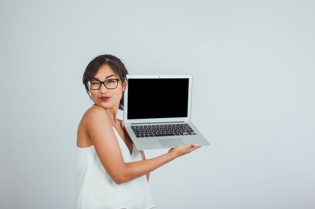 Junge Frau mit Laptop zwinkert