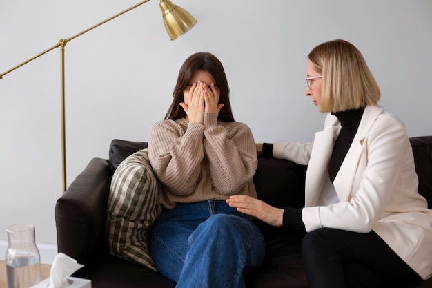 Kostenloses Foto junge frau mit mittlerem schuss, die sich einer therapie unterzieht