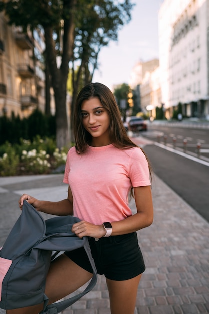 Junge Frau mit offenem Rucksack auf der Straße. Porträt einer jungen Frau