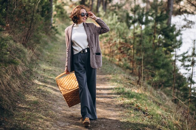 Junge Frau mit Picknickbox im Wald