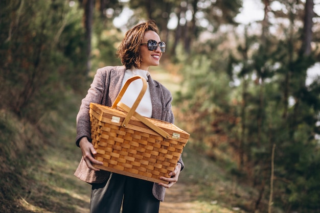 Junge Frau mit Picknickbox im Wald