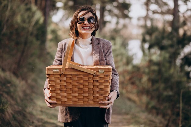 Junge Frau mit Picknickbox im Wald