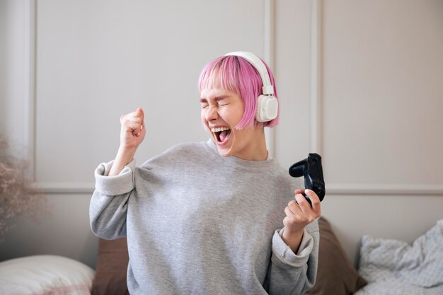 Junge Frau mit rosa Haaren, die ein Videospiel spielen