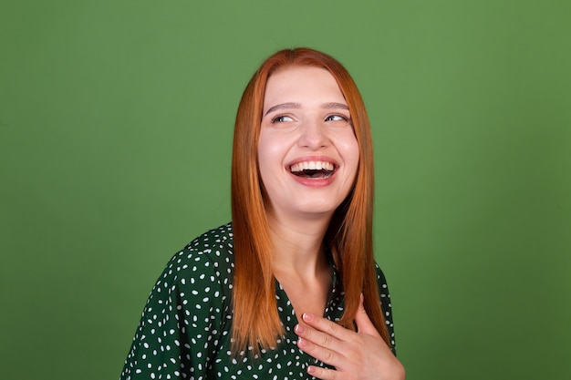 Kostenloses Foto junge frau mit rotem haar auf grüner wand lächelt und lacht, gute laune, positive emotionen