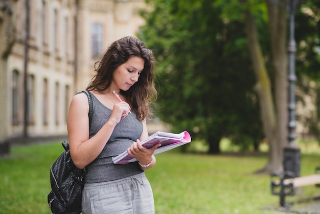 Junge frau mit rucksack und bücher