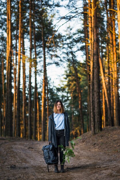 Junge Frau mit Rucksack und Zweig