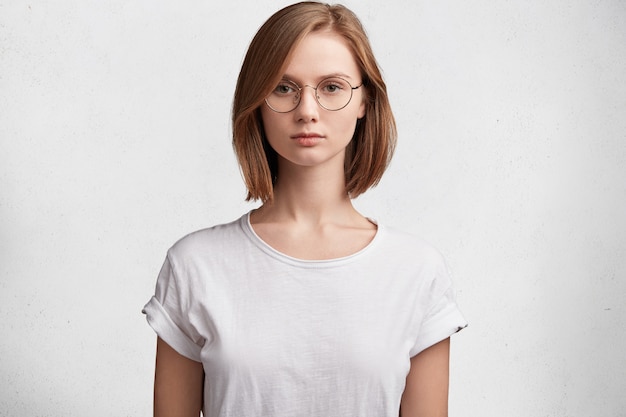 Junge Frau mit runder Brille und weißem T-Shirt