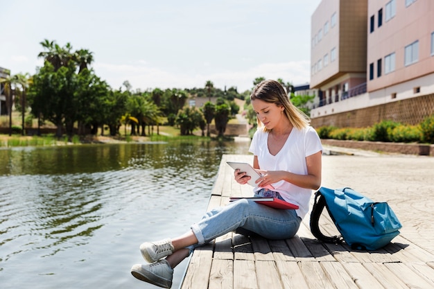 Junge Frau mit Tablette im Campus nahe See