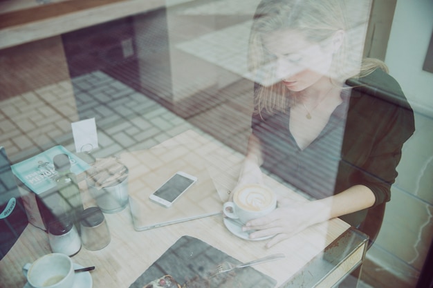 Kostenloses Foto junge frau mit tasse kaffee im café