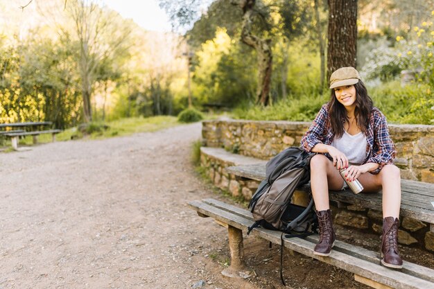 Junge Frau mit Thermosflasche im Park