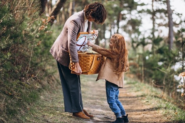 Junge Frau mit Tochter im Wald mit Picknickbox